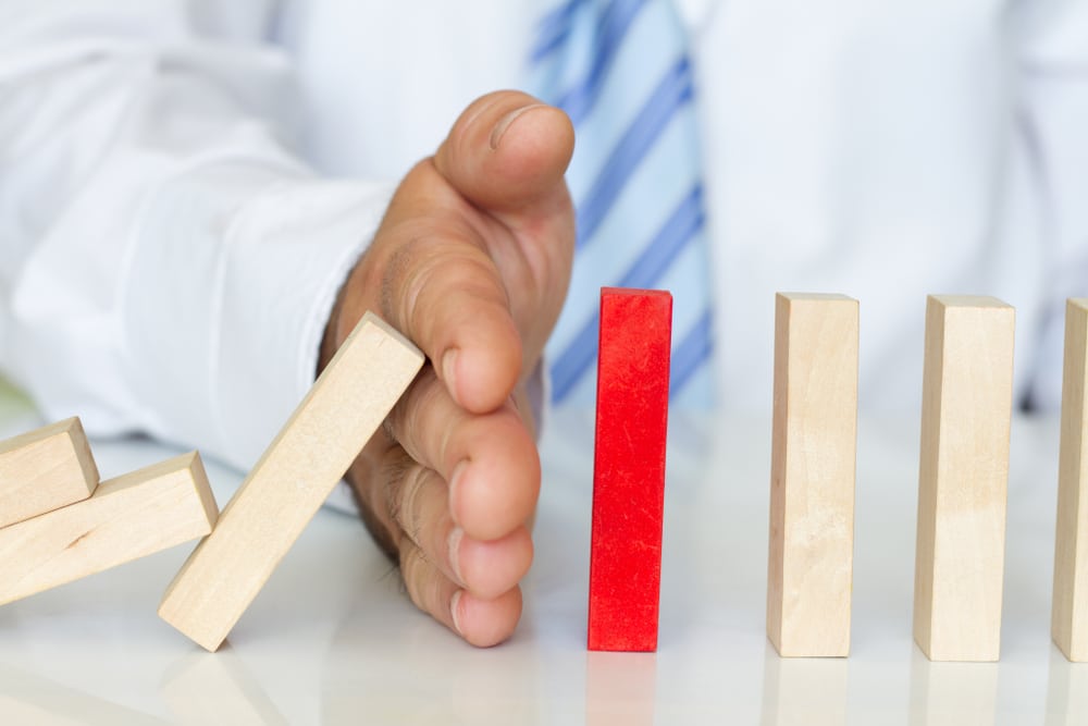 image of hand and wood colored dominoes