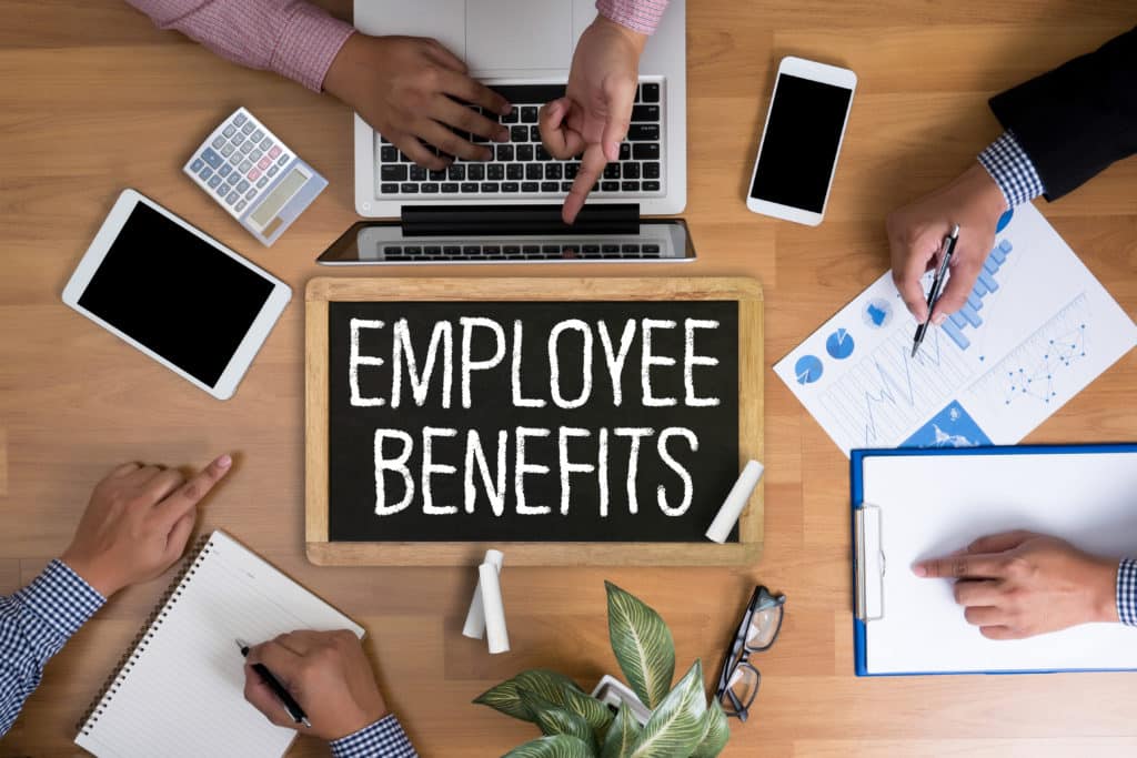 Employee cost calculator blog post image showing employee benefits on a blackboard